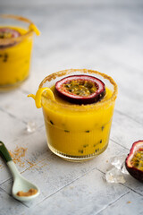 Mango and Passion fruit smoothie on a grey background. Exotic tropical vitamin drink from fresh...