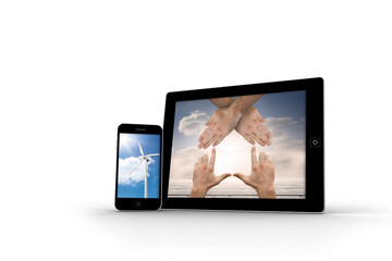 Hands and wind turbine on smartphone and tablet screens