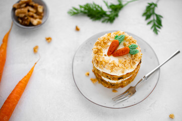 Easter Carrot cake with cream cheese frosting and marzipan decorations on a white stone background for festive dinner. Small easter bento cake. Fresh homemade carrot dessert. Traditional Easter food.