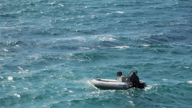 Inflatable emergency rescue motor boat swing on sea waves
