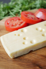 sliced cheese with holes on a chopping board on table 