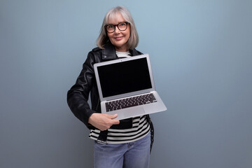 smart 60s mature old business woman with gray hair using laptop with mockup on bright background