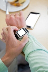 Cropped image of man holding smart watch