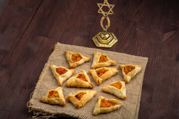 Triangular gomentashi cookies for the holiday of Purim are laid out on a checkered napkin.
