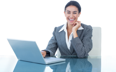 Cheerful businesswoman using laptop at desk