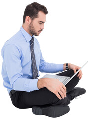 Cheerful businessman sitting on the floor using laptop