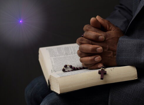 man praying to god with hands together Caribbean man praying with black background stock photos stock photo	
