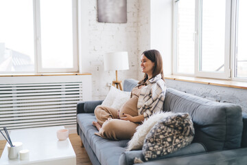 Young woman carrying baby sitting in cozy lounge
