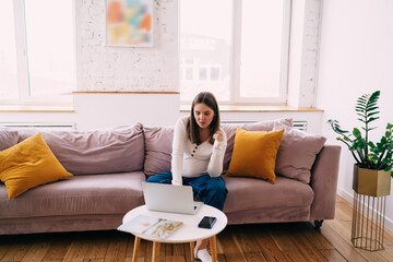 Pregnant woman using laptop in living room