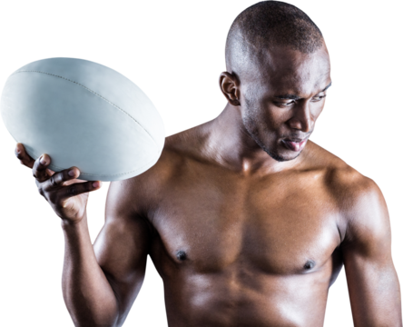 Concentrated shirtless sportsman holding rugby ball