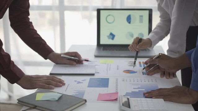 Businessmen summarizing their work in the company during the year new project in the office Young entrepreneurs brainstorm to analyze and plan business strategies.