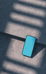 Smartphone mockup, laying on a concrete surface, outdoor
