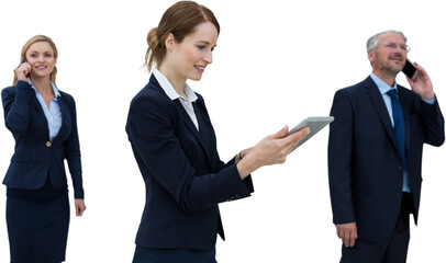 Businesswoman using tablet while colleagues talking on phone