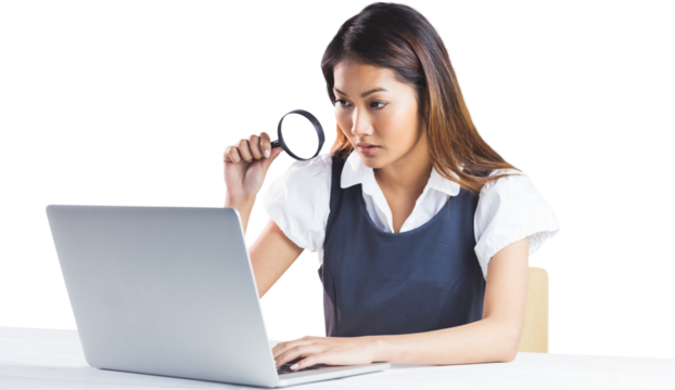 Businesswoman looking through magnifying glass and using laptop - Powered by Adobe