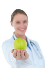 Smiling doctor offering an apple 