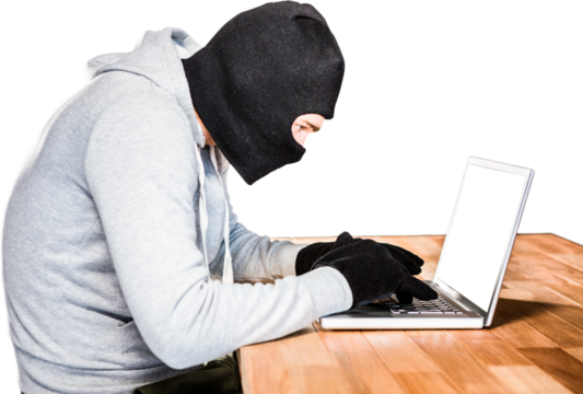 Focused thief with hood typing on laptop