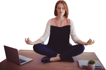 Businesswoman meditating while sitting on desk