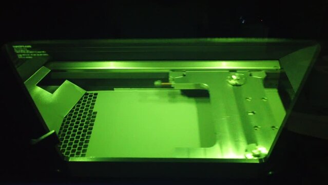 Working 3d printer for metal. 3D printer printing object from metal powder in working chamber by sintering metal powder under laser. SLM. Selective laser melting technology. Melting metal powder