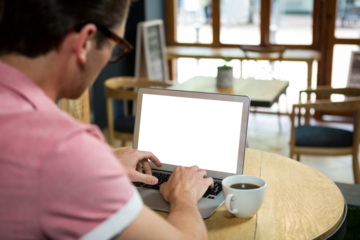 Man using laptop in cafe