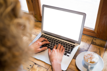 Cropped image of woman using laptop