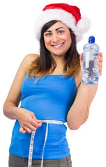 Festive fit brunette measuring her waist and holding bottle