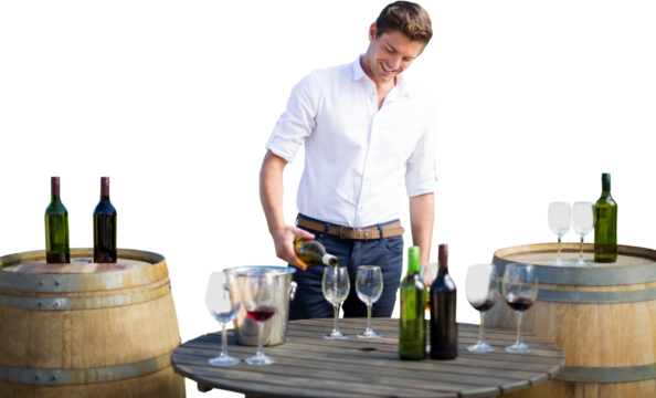 Smiling young man pouring wine in glasses on barrel - Powered by Adobe