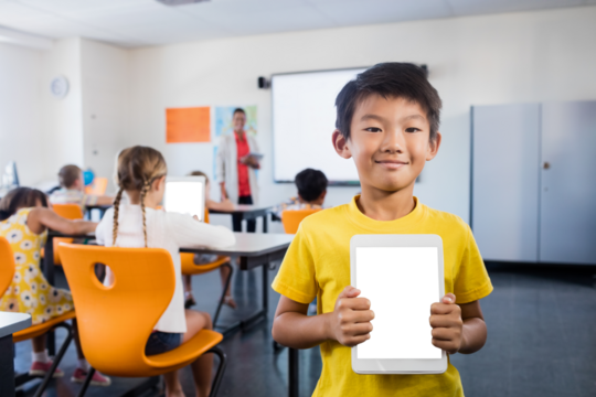 Small boy holding digital tablet and standing