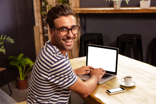 Happy man using laptop at cafe