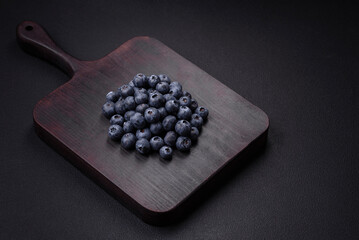 Delicious fresh blueberries on a textural black concrete background