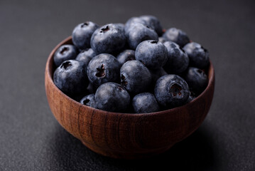 Delicious fresh blueberries on a textural black concrete background