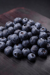 Delicious fresh blueberries on a textural black concrete background