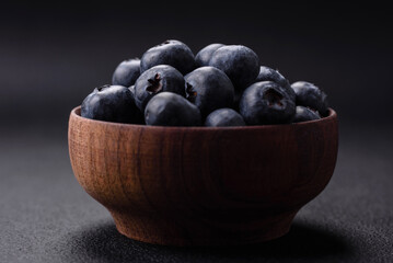 Delicious fresh blueberries on a textural black concrete background