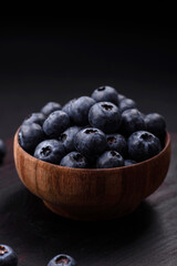 Delicious fresh blueberries on a textural black concrete background