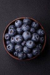 Delicious fresh blueberries on a textural black concrete background