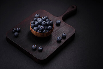 Delicious fresh blueberries on a textural black concrete background