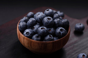 Delicious fresh blueberries on a textural black concrete background