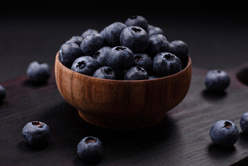 Delicious fresh blueberries on a textural black concrete background