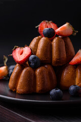 Delicious cupcakes or muffins with raisins and nuts, strawberries and blueberries