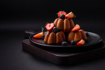 Delicious cupcakes or muffins with raisins and nuts, strawberries and blueberries