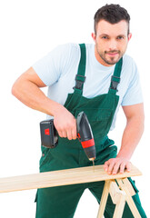 Carpenter drilling hole in plank 
