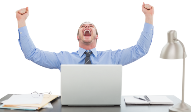 Successful businessman with hands raised sitting at desk