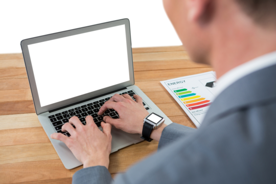 Businessman typing on digital laptop at table