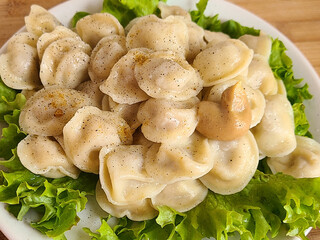 Dumplings with sour cream and mustard on a wooden background