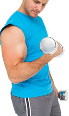 Mid section of a fit young man exercising with dumbbells