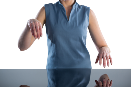 Mid section of young businesswoman using imaginary interface at table