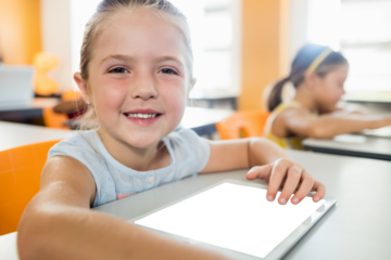 Smiling girl sitting and using digital tablet