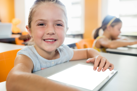 Smiling girl sitting and using digital tablet