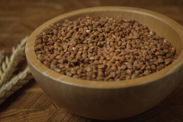 Obraz na płótnie Canvas Buckwheat on a wooden board. Buckwheat on top. Buckwheat in a bowl. Cereals