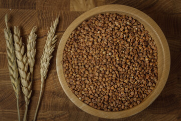 Buckwheat on a wooden board. Buckwheat on top. Buckwheat in a bowl. Cereals