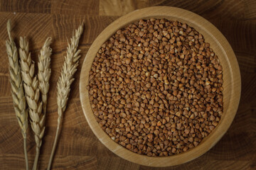Buckwheat on a wooden board. Buckwheat on top. Buckwheat in a bowl. Cereals